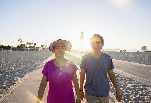 people man and woman walking on gray asphalt person