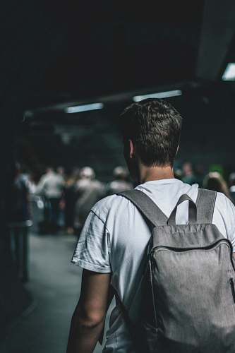 person man carrying backpack standing people