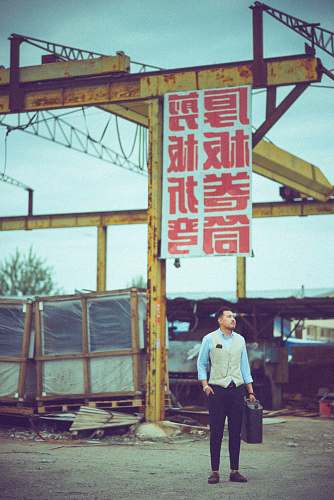 people man carrying case standing near signage board person