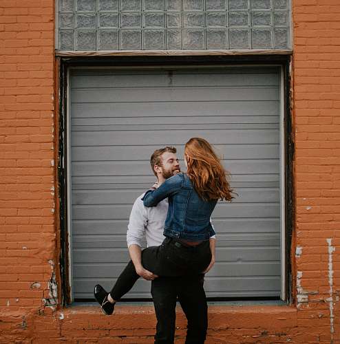 people man carrying woman near shutter door person