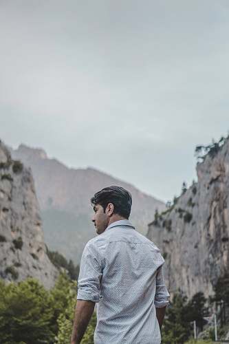 people man facing rock formation at daytime person