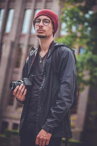 people man holding black DSLR camera person