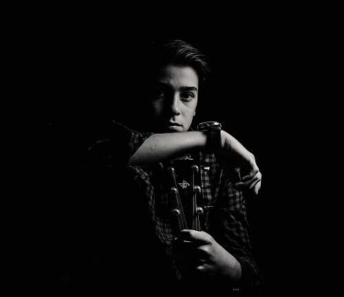 person man holding guitar black-and-white