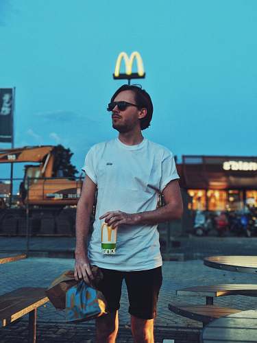 people man holding McDonald cup beside camping table person