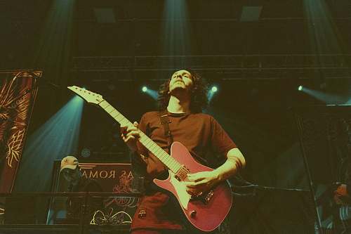people man holding red electric guitar person