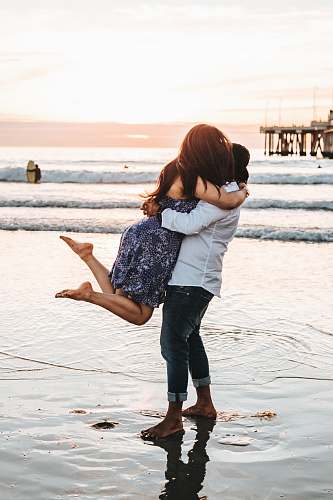 people man hugging woman on seashore person