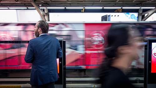 people man in black suit jacket standing train