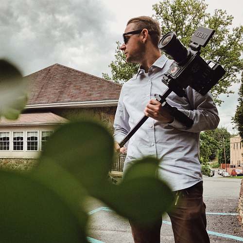 people man in gray dress shirt holding camera person