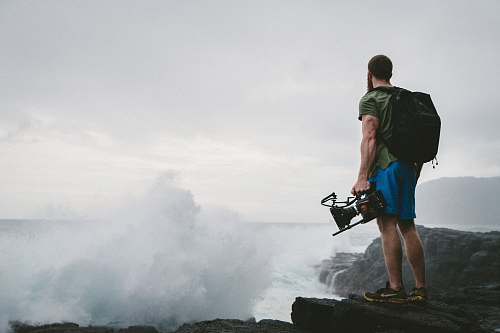 people man in green shirt standing near clouds person