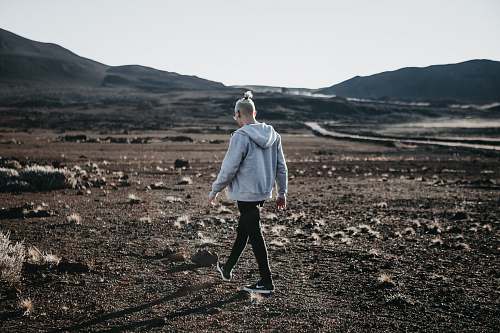 people man in hoodie walking on open field person