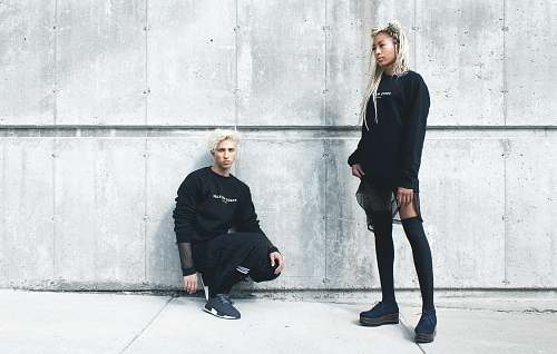 people man kneeling and woman standing near wall person