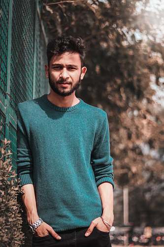 people man leaning against green wall person