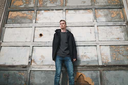 people man leaning on white wooden wall person