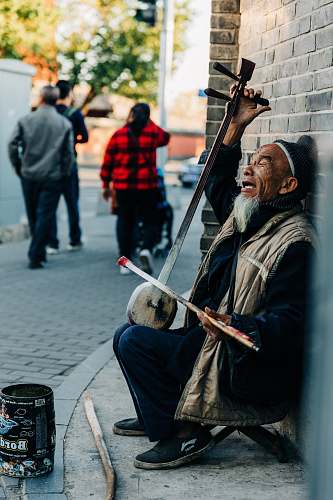 people man playing musical instrument on sidewalk person
