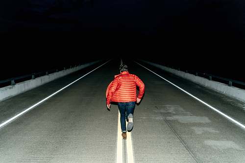 people man running on road during night time person