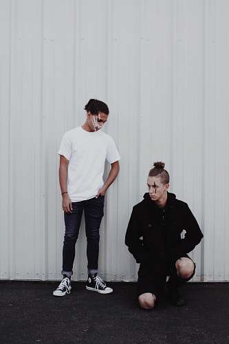 people man sitting beside man standing near the wall person