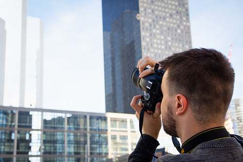 people man standing and taking photo of high-rise buildings person