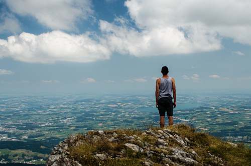 people man standing at peak of mountain person