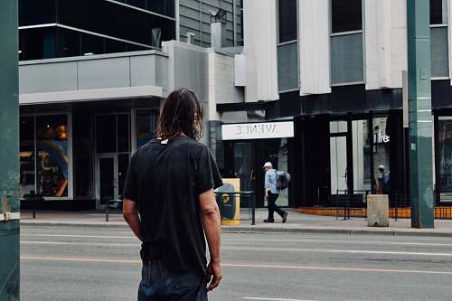 people man standing beside road near Avenue storefront person