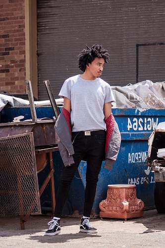 people man standing in front of blue container looking sideways person