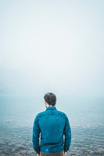 people man standing in front of body of waterf person
