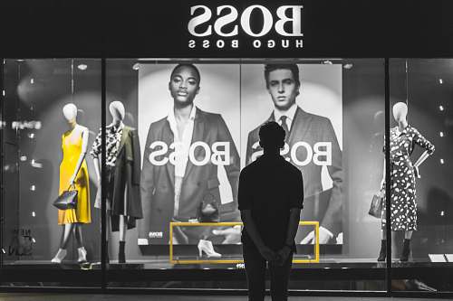 person man standing in front of Boss Hugo Boss store people