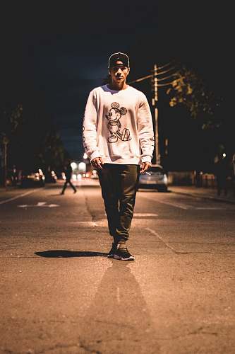 people man standing in the middle of road during nighttime person