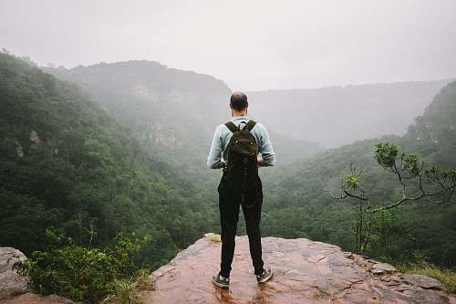 people man standing near cliff overlook mountains person