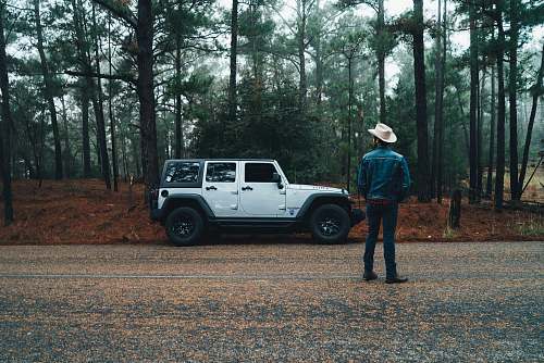 car man standing near white and black car jeep