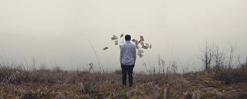 person man standing on grass grey