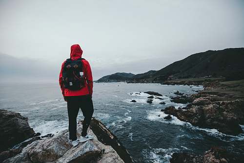 people man standing on gray and black rock formation person