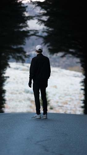 people man standing on pathway with trees person