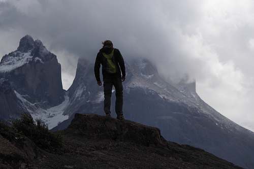person man standing on peak mountain