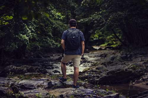 people man standing on rock near body of water person