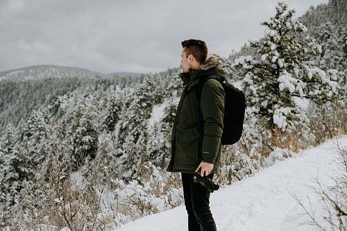 people man standing on snow-covered land during daytime person