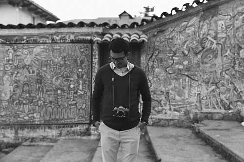 people man standing outside building black-and-white