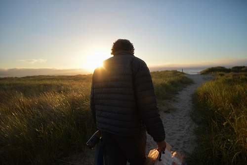 person man walking across the road during sunrise people