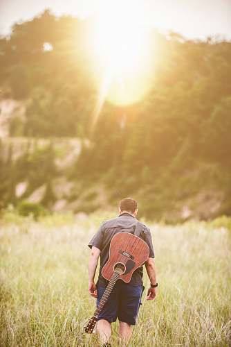 people man walking on green grass field during daytime person