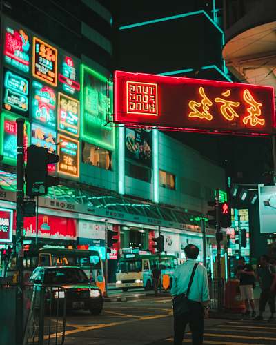 people man walking on street under tung fong hung signage person