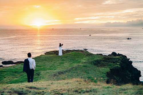 people man walking towards woman standing on cliff person