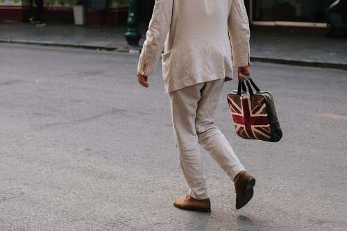 people man walking while holding handbag person
