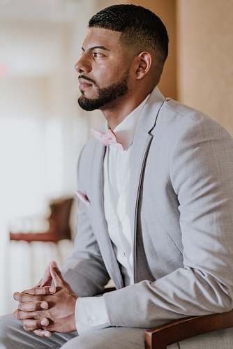 people man wearing gray and white tuxedo while sitting on chair person
