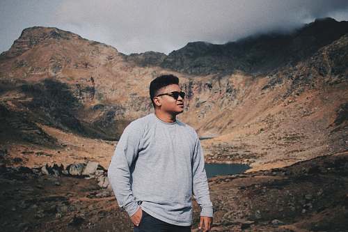 people man wearing sweater and sunglasses with mountain background person