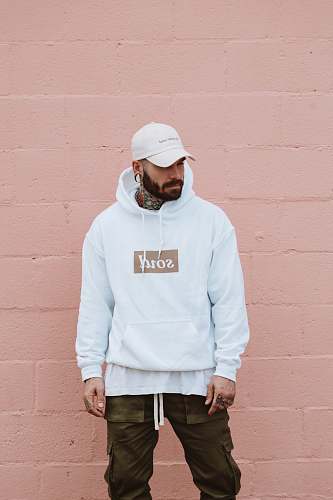 people man wearing white pullover hoodie standing against the wall person