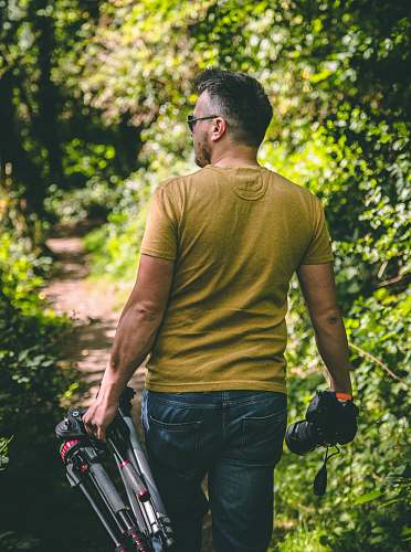 people man wearing yellow T-shirt holding tripod and DSLR camera person