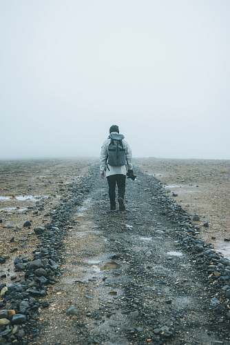 people man with backpack walking on brown field person