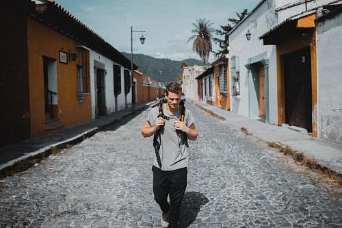 people one unknown celebrity in gray shirt walking between houses person