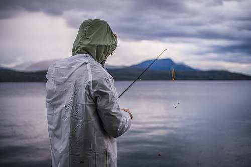 people person fishing on body of water person