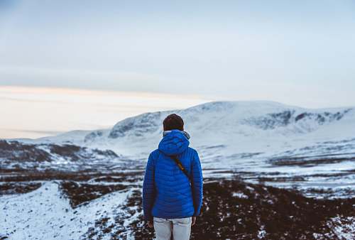 people person in blue hoodie facing snow covered hill person