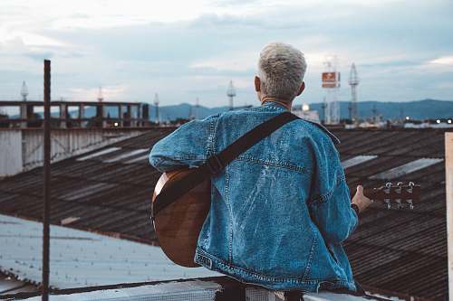 person person playing guitar on rooftop people